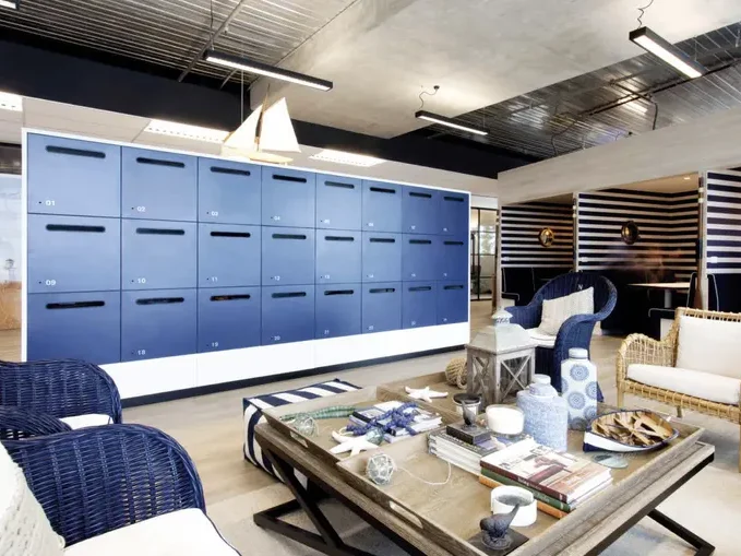Moderne Lounge mit blauen Schränken, gemütlichen Sitzmöbeln und einem Tisch.