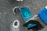 Hand hält ein Smartphone an ein iLOQ Rohrschloss.